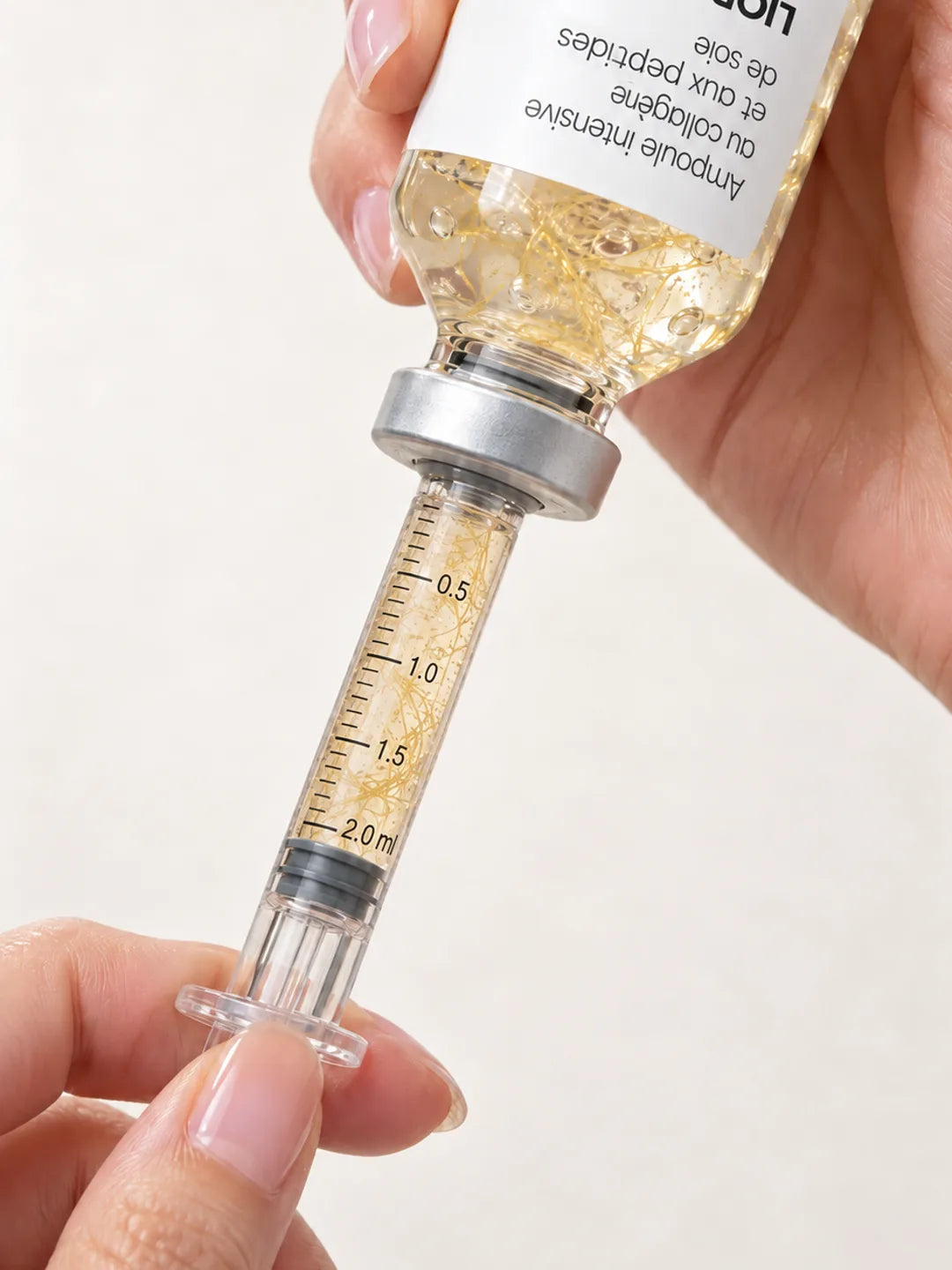 L’applicateur prélève le sérum dans l’ampoule