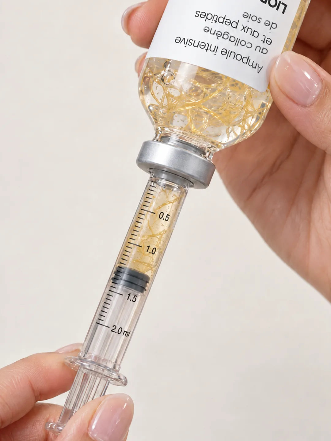 L’applicateur inséré dans le bouchon prélève le sérum jusqu’au trait de 1 ml